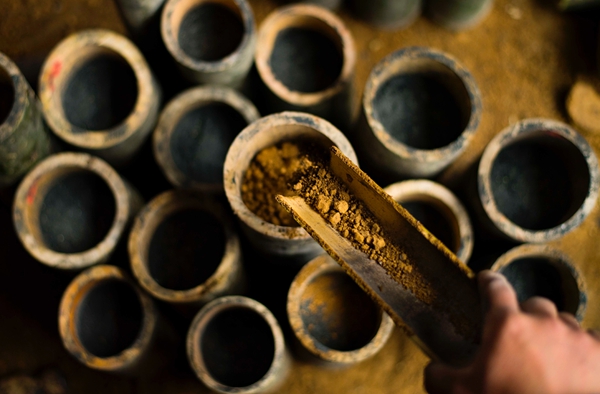 钢火师为装好火药的竹筒进行封底.